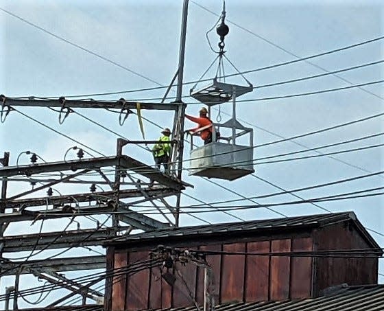 Two members of the International Brotherhood of Electrical Workers Local 1105 clean insulators at a local jobsite. The electrical field is on the rise in the local area due to a variety of home and industrial builds.