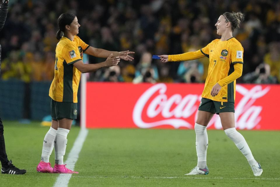 Australia's Sam Kerr, left, enters the pitch during the Women's World Cup round of 16 soccer match between Australia and Denmark at Stadium Australia in Sydney, Australia, Monday, Aug. 7, 2023. (AP Photo/Mark Baker)