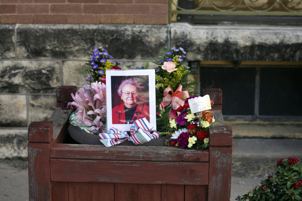 A photo surrounded by flowers in honor of the late Marion County Record co-owner Joan Meyer sits outside the newspaper's office on Monday. 