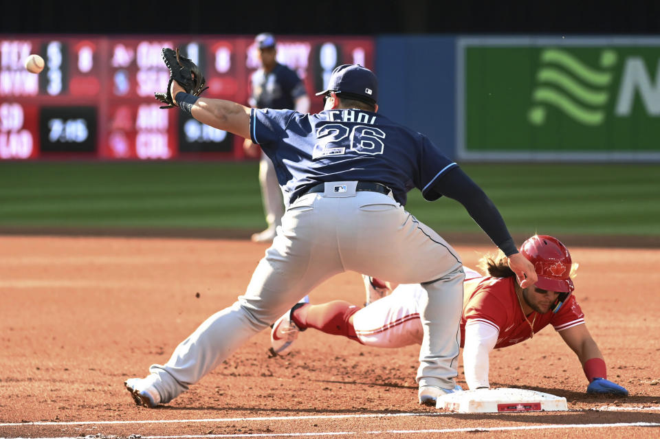 Toronto Blue Jays' Bo Bichette dives safely back into first base ahead of the throw to Tampa Bay Rays first baseman Ji-Man Choi during the first inning of the second baseball game of a doubleheader Saturday, July 2, 2022, in Toronto. (Jon Blacker/The Canadian Press via AP)