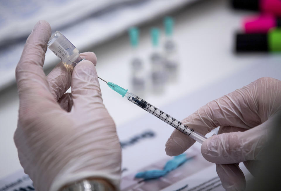 An employee of the vaccination campaign prepares Biontech doses against the COVID-19 disease in Osnabueck, Germany, Saturday, Nov. 13, 2021. Germany has struggled to bring new momentum to its vaccination campaign lately, with a bit over two-thirds of the population fully vaccinated, and has balked so far at ordering vaccine mandates for any professional group. (Lino Mirgeler/dpa via AP)