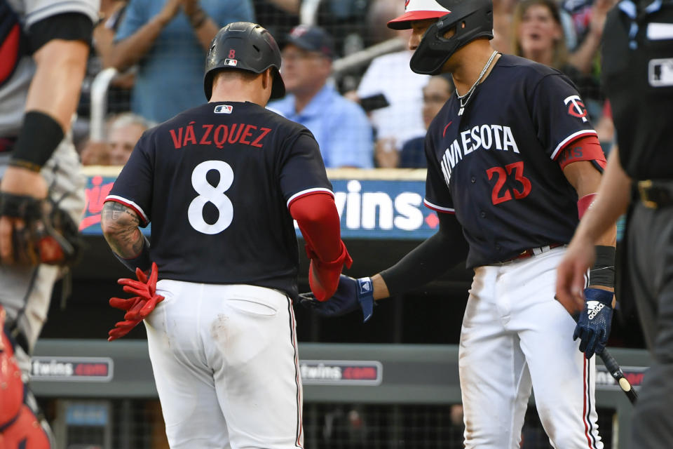 Minnesota Twins' Christian Vazquez (8) celebrates with Royce Lewis (23) after scoring on a Donovan Solano double against the Cleveland Guardians during the fifth inning of a baseball game, Saturday, June 3, 2023, in Minneapolis. (AP Photo/Craig Lassig)