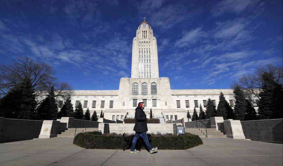 A pedestrian walks past the Nebraska State Capitol building in Lincoln, Neb., on Wednesday, Jan. 4, 2017. Lancaster County is among the most evenly split on political lines of any major county in the nation. (AP Photo/Charlie Neibergall)