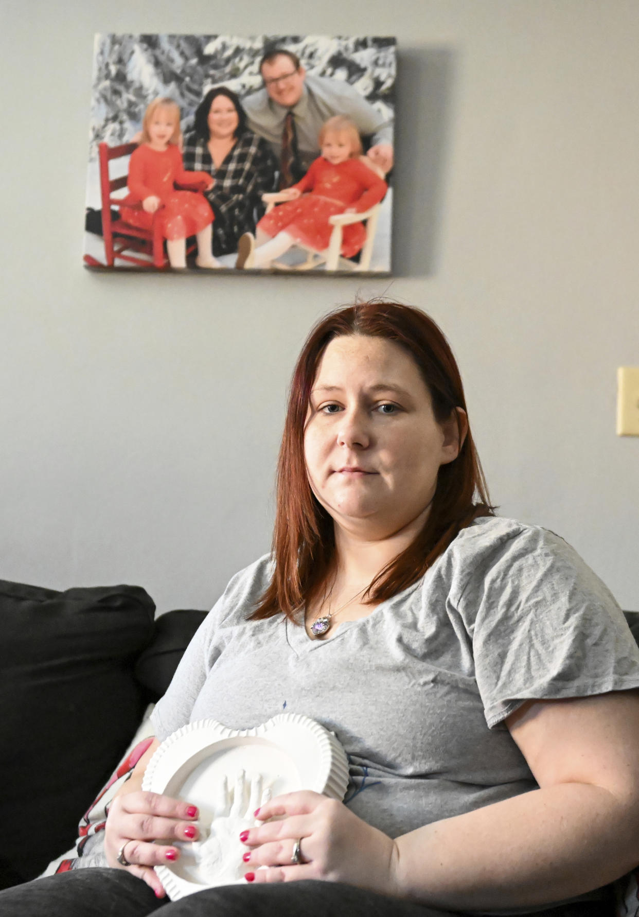 Jessica Day-Weaver holds a ceramic hand print of her daughter, Anastasia, at her home, Thursday, Feb. 2, 2022, in Boardman, Ohio. (AP Photo/Nick Cammett)