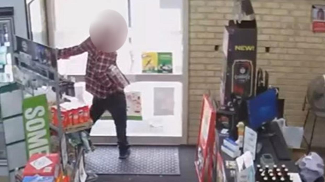 A man has been caught on CCTV trying to run off with a box of drinks from a bottle-o before becoming stuck in the store. Picture: Facebook