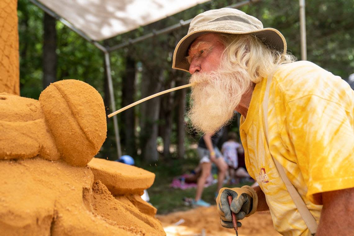 Ed Moore, a sand sculptor at Sandy Feat, works on sculpting a Damselfly at the Festival for the Eno on Saturday, July 2, 2022.