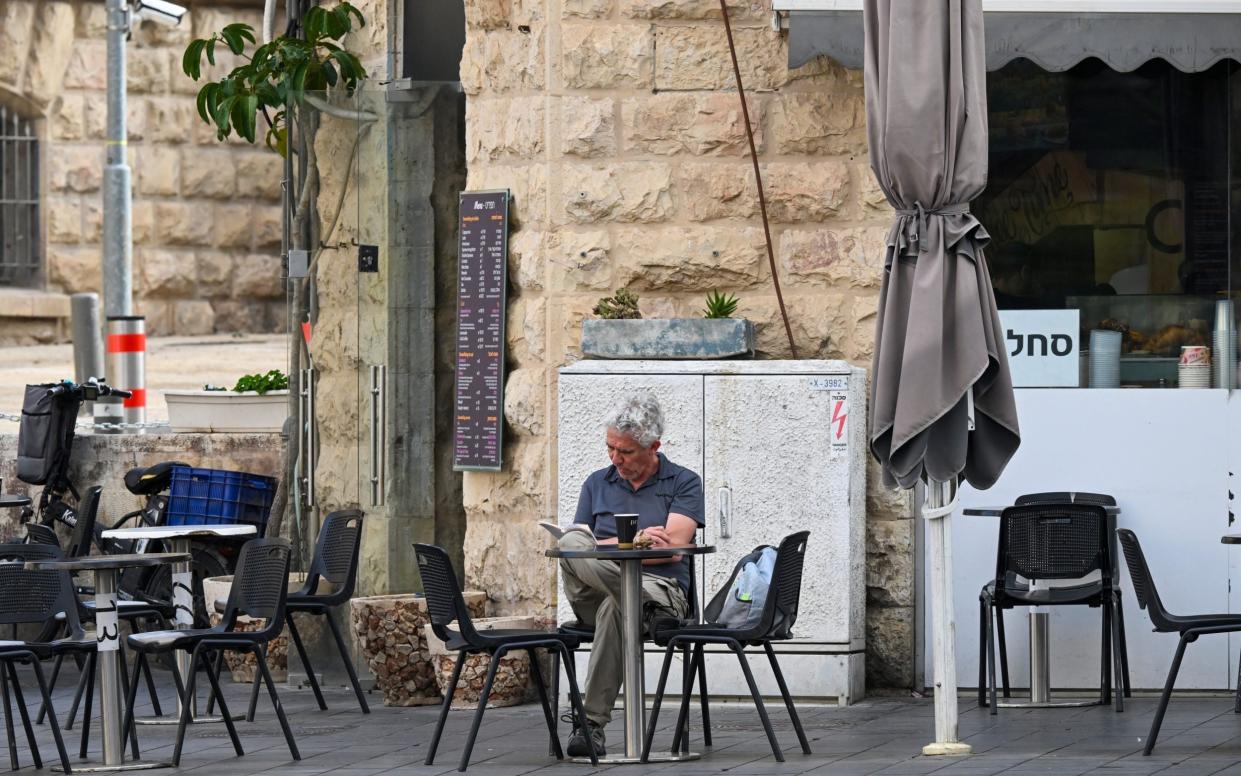 A man reads at a cafe in Jerusalem