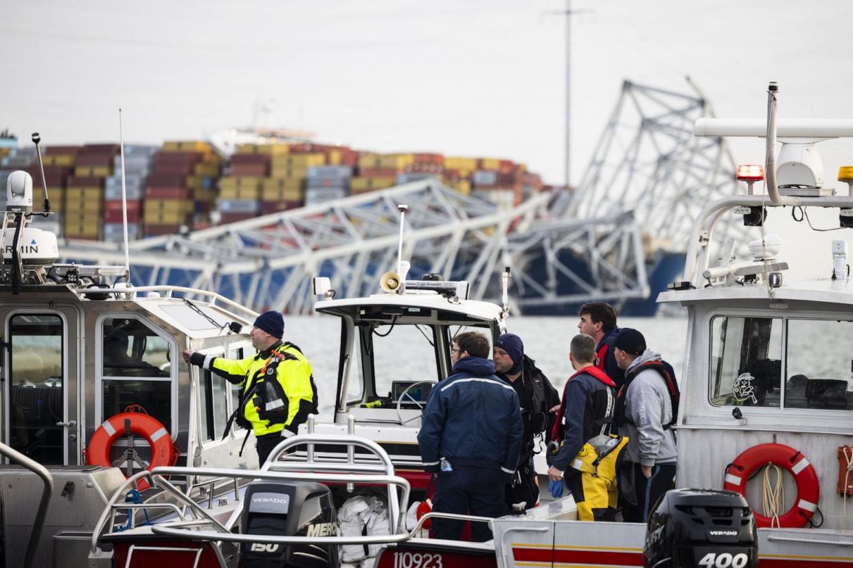 PHOTO: Rescue personnel gather on the shore of the Patapsco River after a container ship ran into the Francis Scott Key Bridge (back) causing its collapse in Baltimore, March 26, 2024.  (Jim Lo Scalzo/EPA via Shutterstock)