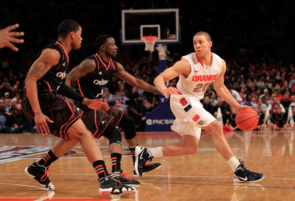 NEW YORK, NY - MARCH 09: Brandon Triche #20 of the Syracuse Orange handles the ball against Dion Dixon #3 and Cashmere Wright #1 of the Cincinnati Bearcats during the semifinals of the Big East men's basketball tournament at Madison Square Garden on March 9, 2012 in New York City. (Photo by Chris Trotman/Getty Images)