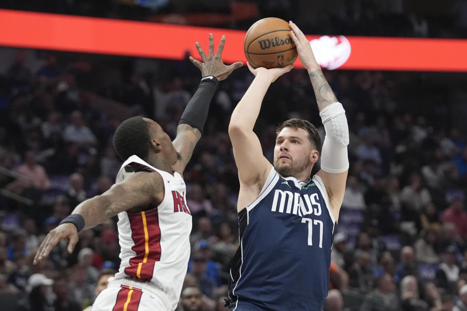 Dallas Mavericks guard Luka Doncic (77) shoots against Miami Heat guard Terry Rozier, left, during the first half of an NBA basketball game in Dallas, Thursday, March 7, 2024. (AP Photo/LM Otero)