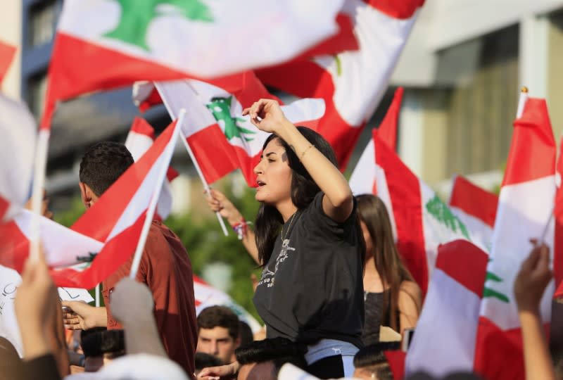 Demonstrators carry national flags during an anti-government protest in the port city of Sidon