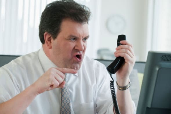 Angry business man yelling at phone