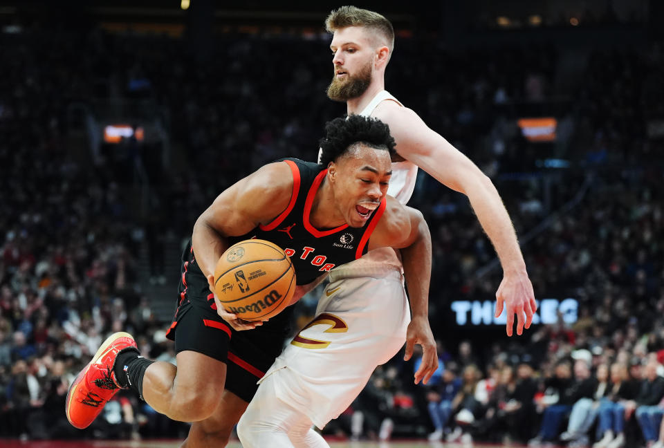 Toronto Raptors forward Scottie Barnes, left, is fouled by Cleveland Cavaliers forward Dean Wade (32) during the first half of an NBA basketball game, Saturday, Feb. 10, 2024 in Toronto. (Frank Gunn/The Canadian Press via AP)