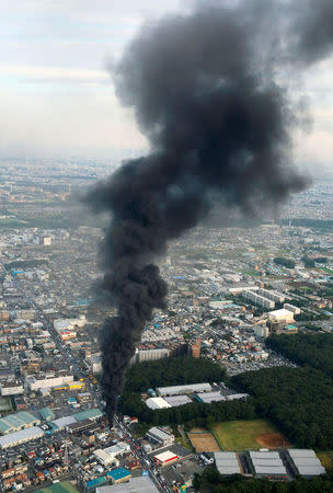 Black smoke spews from an unmanned underground cable facility in Niiza, Saitama prefecture, Japan October 12, 2016. Kyodo/via REUTERS