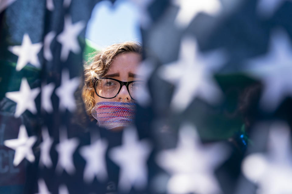FILE - Emma Rousseau of Oakland, N.J., her mouth bound with a red, white and blue netting, attends a rally on the Fourth of July to protest for abortion rights, at Lafayette Park in front of the White House in Washington, July 4, 2022. There's action on abortion policy in rulings, legislatures, and campaigns for candidates and ballot measures on the 51st anniversary of Roe v. Wade. The 1973 ruling established the right to abortion across the U.S. But things have been in flux since the U.S. Supreme Court overturned it in 2022. Measures to protect abortion access will be on the ballots this year in at least two states — and are under consideration in a dozen more. Activists used Monday, Jan. 22, 2024 for legislative hearings and campaign launches. (AP Photo/Andrew Harnik, File)