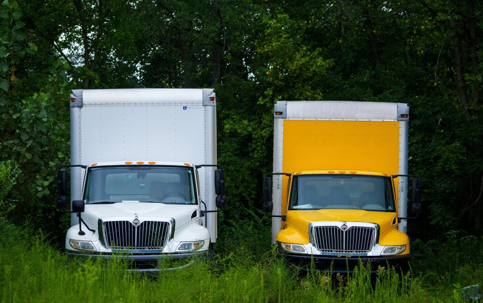 Parked trucks sit near overgrown weeds and a gas canister at a parking lot on English Avenue on the southeast side of Indianapolis.