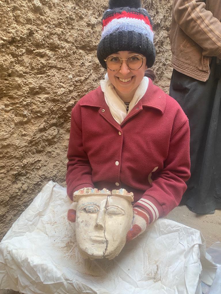 Smith-Sangster holds an anthropoid mask after excavating it from a burial chamber