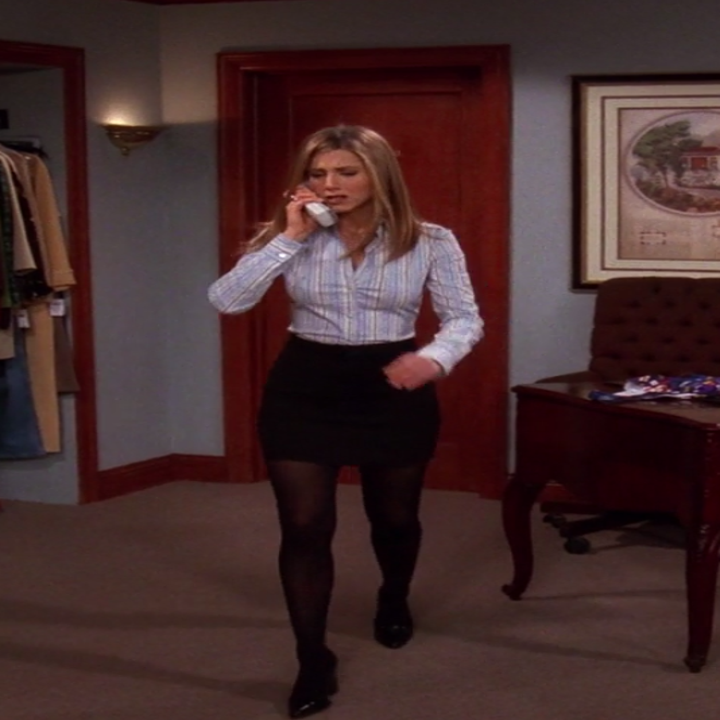 Rachel wearing small boots, tights, a mini skirt, and a long-sleeve button up