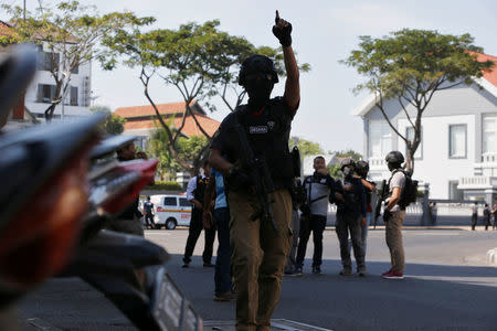 Anti-terror policemen stand guard following a bomb blast at police office in Surabaya, Indonesia May 14, 2018. REUTERS/Beawiharta