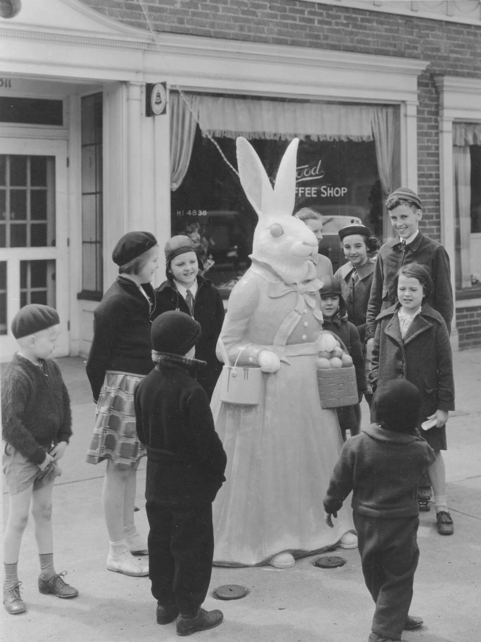 A group of children stands near an Easter bunny statue at Crestwood Shops in 1923. The bunnies were on display outside the Crestwood Shops for nine years before moving to their long-time home on Country Club Plaza.