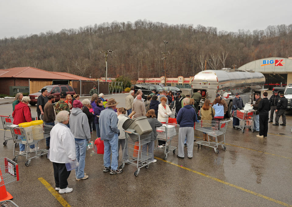 West Virginia State Troopers fill water jugs at the Kmart in Elkview, W.Va., Friday, Jan. 10, 2014. Emergency crews are setting up water depots at many locations around the state following a chemical spill Thursday on the Elk River that compromised the public water supply to nine counties. (AP Photo/Tyler Evert)