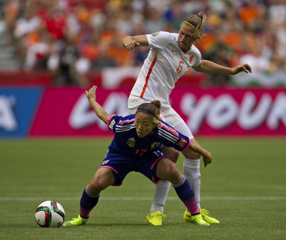 La delantera de Japón, Yuki Ogimi (izq.) y la centrocampista de Holanda, Anouk Dekker pelean por la bola en el partido entre ambas selecciones por el Mundial femenino de fútbol Canadá-2015, el 23 de junio de 2015 (AFP | Andy Clark)