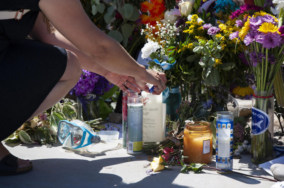 Una mujer enciende una vela en un memorial para las víctimas del buque de buceo Conception en el puerto de Santa Bárbara el domingo 8 de septiembre de 2019 en Santa Bárbara, California. (AP Foto/Christian Monterrosa)