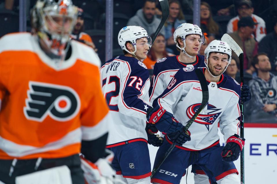 Columbus Blue Jackets' Liam Foudy, right, looks over at Philadelphia Flyers goalie Carter Hart, left, after a goal during the first period an NHL hockey game Tuesday, April 11, 2023, in Philadelphia. (AP Photo/Chris Szagola)