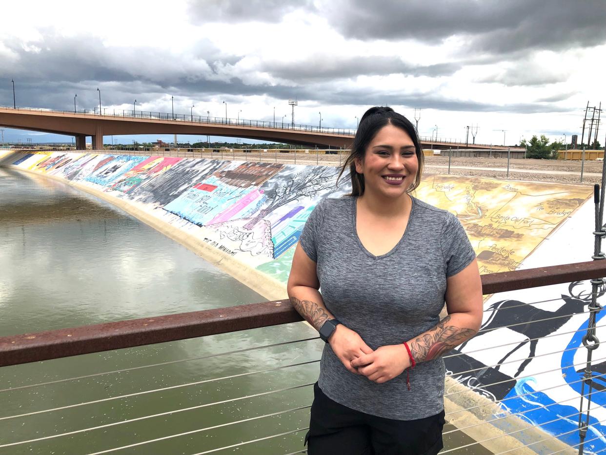 Desiree Talmich stands on the bridge at the Pueblo Levee Mural Project along the Arkansas River.