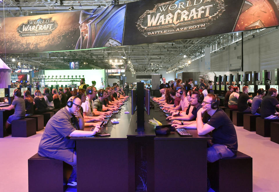 FILE - Visitors try out the latest 'World of Warcraft' video game at the Gamescom fair for computer games in Cologne, Germany, Aug. 21, 2018. American game developer Blizzard Entertainment said Thursday, Nov. 17, 2022, that it will suspend most of its game services in mainland China after current licensing agreements with Chinese games company NetEase end, sending NetEase's shares tumbling. (AP Photo/Martin Meissner, File)
