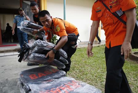Search and rescue workers prepare to load body bags onto a flight to Kalimantan in Pangkal Pinang, Bangka December 30, 2014. REUTERS/Darren Whiteside