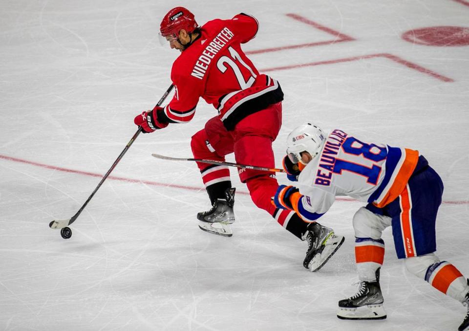 Carolina Hurricanes’ Nino Niederreiter (21) controls the puck ahead of New York Islanders’ Anthony Beauvillier (18) in the third period on Thursday, October 14, 2021 at PNC Arena in Raleigh, N.C.