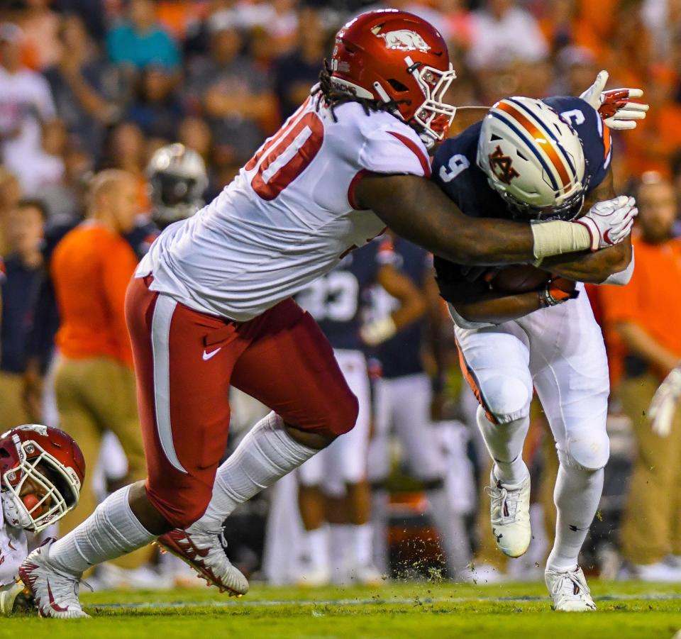 Arkansas defensive lineman Armon Watts (90) wraps up Auburn running back Kam Martin (9) during the first quarter Saturday, Sept. 22, 2018, at Jordan-Hare Stadium in Auburn, Ala. (Julie Bennett/Montgomery Advertiser)