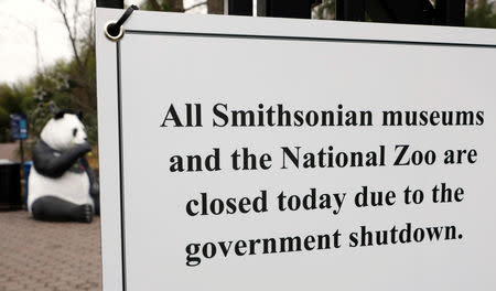 The figure of a panda is seen behind a sign telling the public that the National Zoo is closed due to the partial government shutdown in Washington, U.S., January 2, 2019. REUTERS/Kevin Lamarque