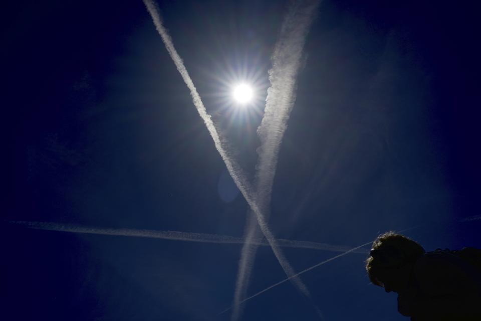 A woman walks at a park during a sunny day in London, Wednesday, Aug. 23, 2023. (AP Photo/Kin Cheung)