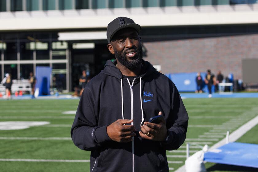 UCLA coach DeShaun Foster stands on the practice field.