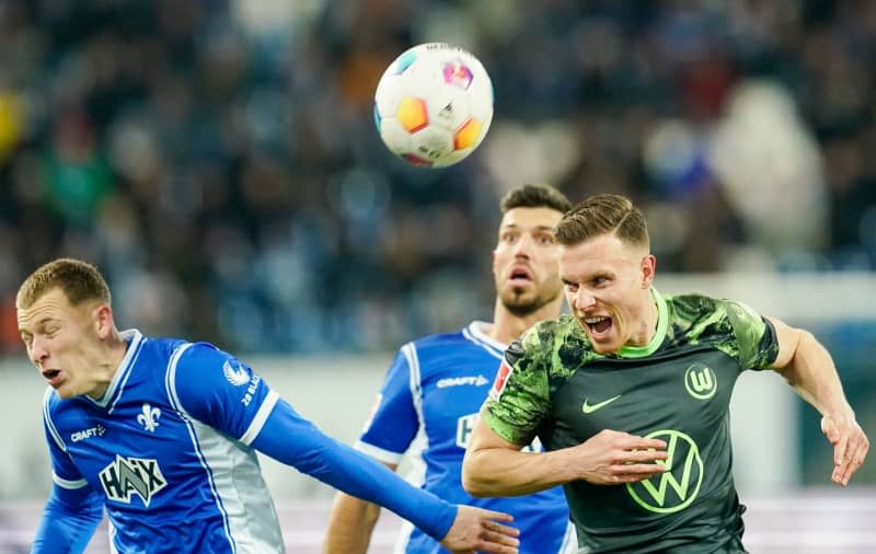 (L-R) Darmstadt's Tim Skarke and Klaus Gjasula battle for the ball with Wolfsburg's Yannick Gerhardt during the German Bundesliga soccer match between SV Darmstadt 98 and VfL Wolfsburg at Merck Stadium at Boellenfalltor. Uwe Anspach/dpa