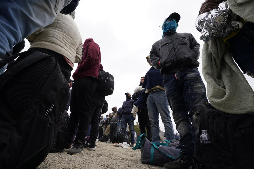 Men, mostly from Colombia, line up as they wait to apply for asylum after crossing the border Wednesday, May 10, 2023, near Jacumba, Calif. The group have been camping just across the border for four days. The Biden administration on Thursday will begin denying asylum to migrants who arrive at the U.S.-Mexico border without first applying online or seeking protection in a country they passed through, marking a fundamental shift in immigration policy as the U.S. readies for the end of a key pandemic restriction. (AP Photo/Gregory Bull)