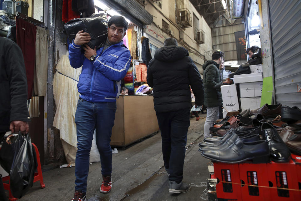 In this Thursday, Feb. 7, 2019 photo, people conduct their business at the Grand Bazaar in Tehran, Iran. The economy faces multiple struggles as the country marks the 40th anniversary of the Islamic Revolution. Inflation continues to rise as its currency depreciates and university graduates are unable to find jobs. Some of the challenges stem from the re-imposition of U.S. sanctions while other problems date back to the time of the revolution. (AP Photo/Vahid Salemi)