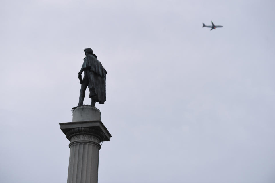 A statue of former U.S. vice president and slavery advocate John C. Calhoun towers over a downtown square Tuesday, June 23, 2020, in Charleston, S.C. Officials in Charleston voted unanimously Tuesday to remove the statue from a downtown square, the latest in a wave of actions arising from protests against racism and police brutality against African Americans. (AP Photo/Meg Kinnard)