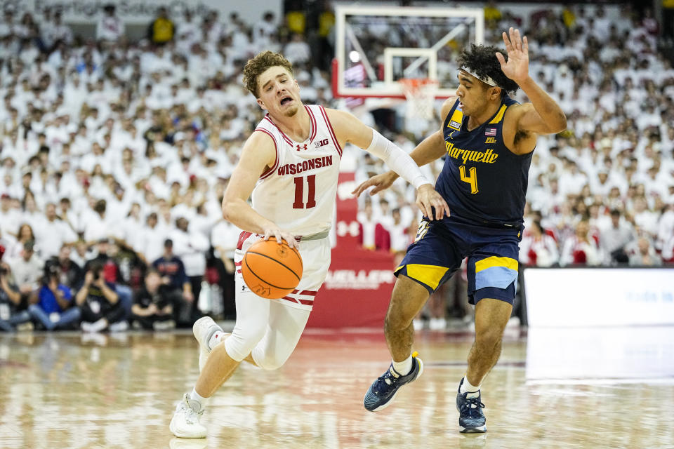 Marquette's Stevie Mitchell (4) fouls Wisconsin's Max Klesmit (11) during the second half of an NCAA college basketball game Saturday, Dec. 2, 2023, in Madison, Wis. (AP Photo/Andy Manis)