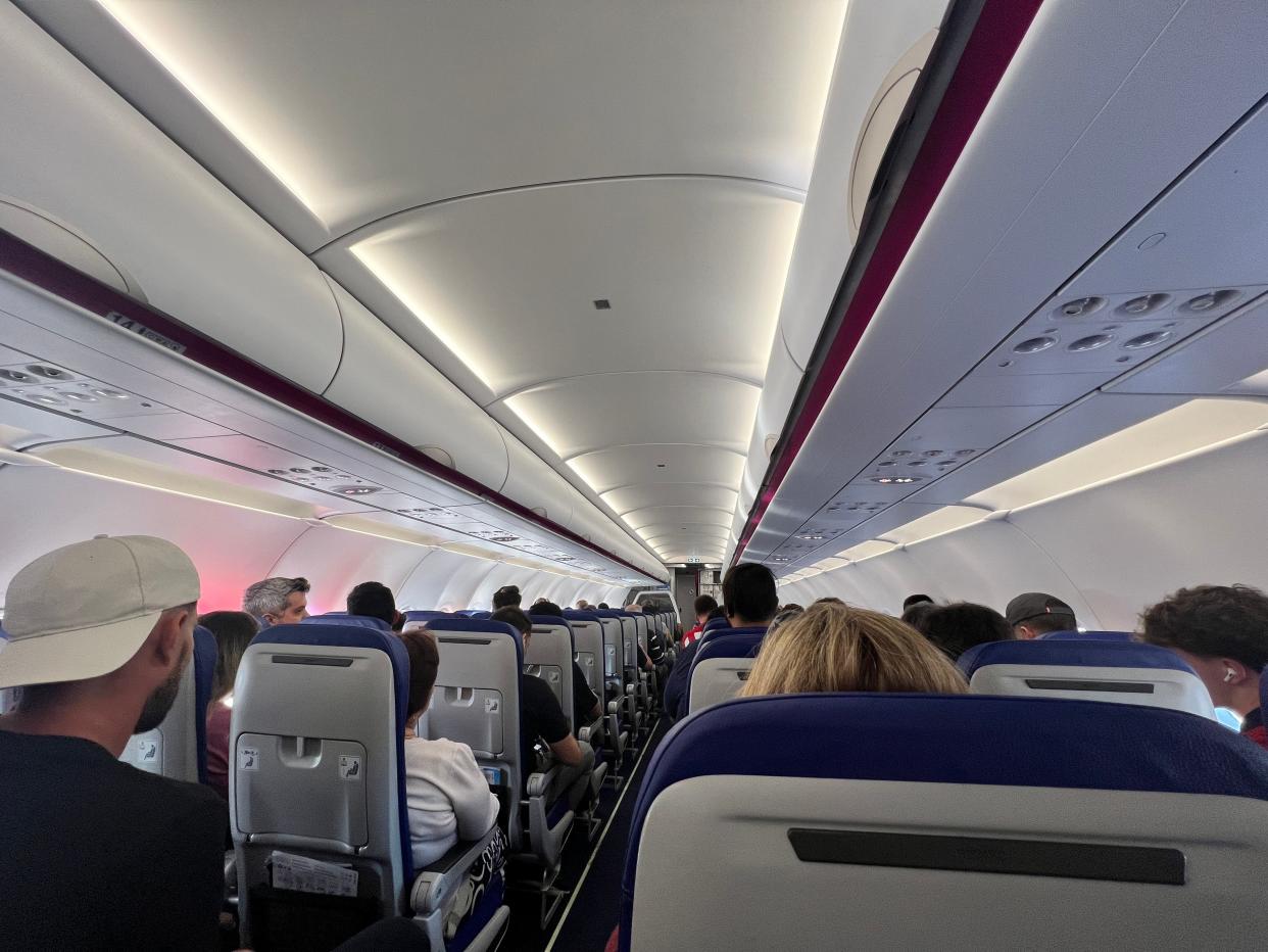 A first-person perspective from the aisle seat of a Wizz Air Airbus A321neo.