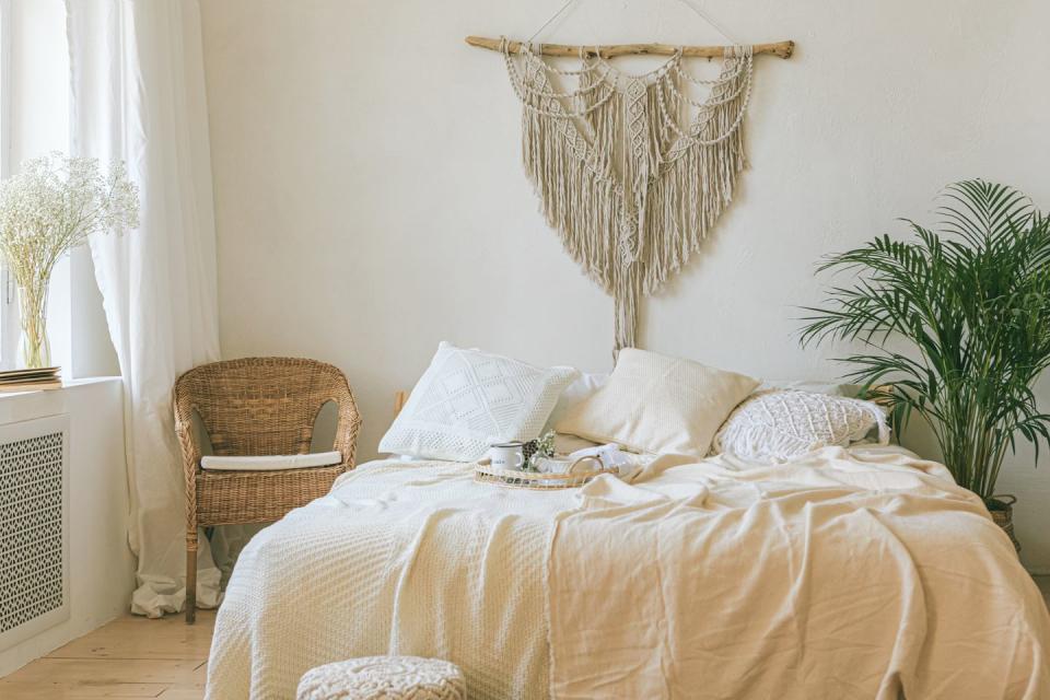 a bed with a chair and a table with a plant on it