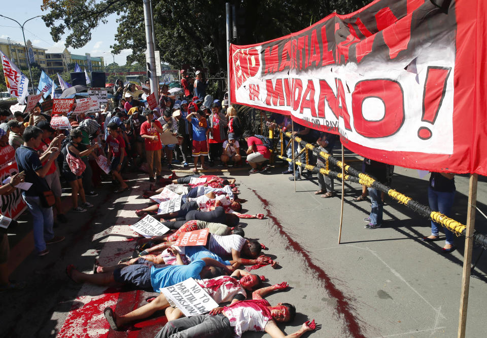 Protesters, with their faces covered with red dye to depict the alleged killings and human rights abuses under Martial Law in the south, stage a die-in during a rally at the Lower House to coincide with the joint Senate and Congress vote for the third extension of Martial Law in southern Philippines Wednesday, Dec. 12, 2018 in suburban Quezon city, northeast of Manila, Philippines. In their statement, various opposition groups condemned the extension of Martial Law which allegedly will "lead to untimely death of more community leaders, human rights defenders, Indigenous Peoples, and Muslim opposition groups." (AP Photo/Bullit Marquez)