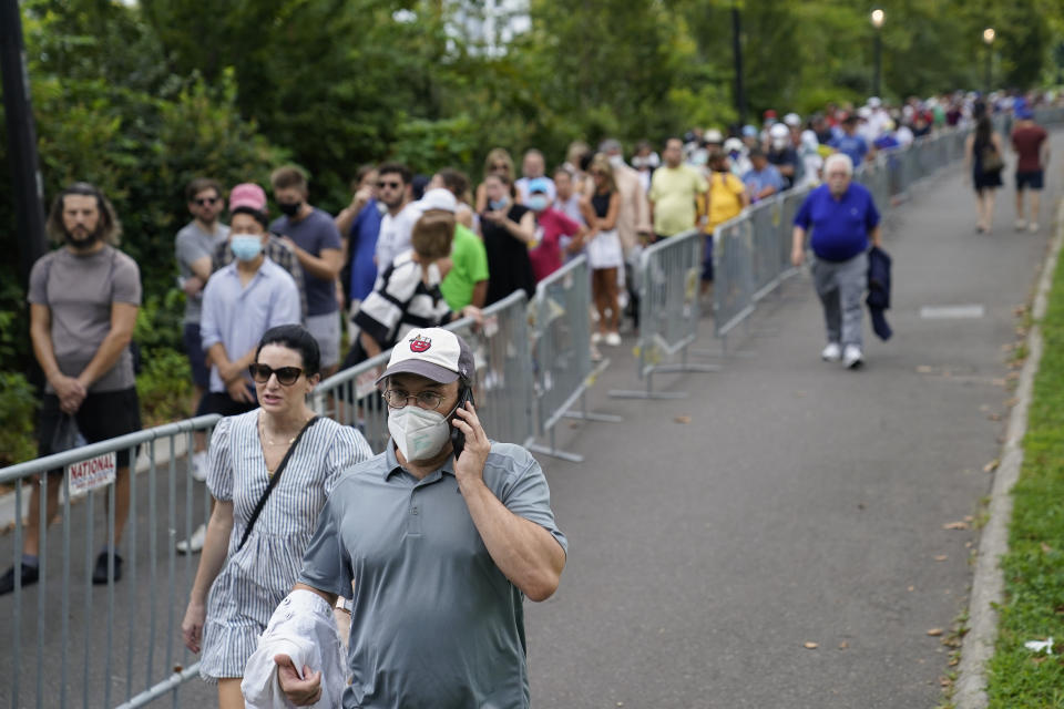 Tennis fans line up outside the Billie Jean King National Tennis Center to attend the first round of the US Open tennis championships, Monday, Aug. 30, 2021, in New York. (AP Photo/John Minchillo)