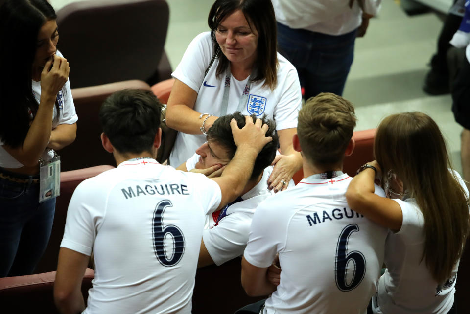 Family time: Harry Maguire is comforted by his mum and brothers at the Luzhniki Stadium