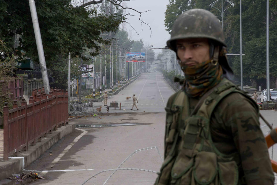 Indian paramilitary soldier stands guard on a deserted road leading towards Independence Day parade venue during lockdown in Srinagar, Indian controlled Kashmir, Thursday, Aug. 15, 2019.Indian Prime Minister Narendra Modi says that stripping the disputed Kashmir region of its statehood and special constitutional provisions has helped unify the country. Modi gave the annual Independence Day address from the historic Red Fort in New Delhi as an unprecedented security lockdown kept people in Indian-administered Kashmir indoors for an eleventh day. (AP Photo/ Dar Yasin)