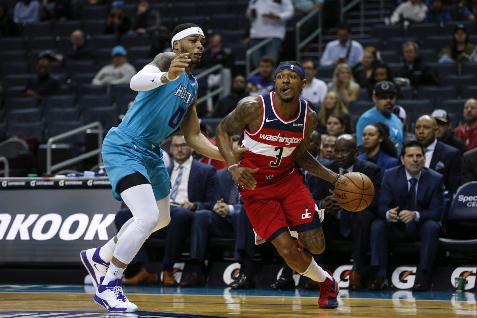 Washington Wizards guard Bradley Beal, right, drives past Charlotte Hornets forward Miles Bridges in the first half of an NBA basketball game in Charlotte, N.C., Tuesday, Dec. 10, 2019. (AP Photo/Nell Redmond)
