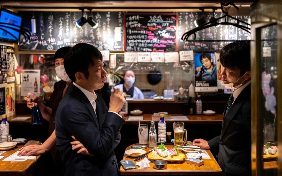 People dine in Tokyo's Shimbashi area ahead of a new state of emergency - Charly Triballeau/AFP