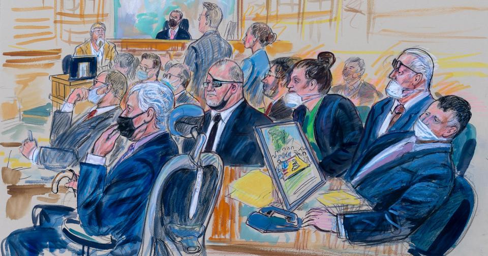 This artist sketch depicts the trial of Oath Keepers leader Stewart Rhodes and four others charged with seditious conspiracy in the Jan. 6, 2021, Capitol attack, in Washington, Thursday, Oct. 6, 2022. Shown above are, witness John Zimmerman, who was part of the Oath Keepers North Carolina Chapter, seated in the witness stand, defendant Thomas Caldwell, of Berryville, Va., seated front row left, Oath Keepers leader Stewart Rhodes, seated second left with an eye patch, defendant Jessica Watkins, of Woodstock, Ohio, seated third from right, Kelly Meggs, of Dunnellon, Fla., seated second from right, and defendant Kenneth Harrelson, of Titusville, Fla., seated at right. Assistant U.S. Attorney Kathryn Rakoczy is shown in blue standing at right before U.S. District Judge Amit Mehta.